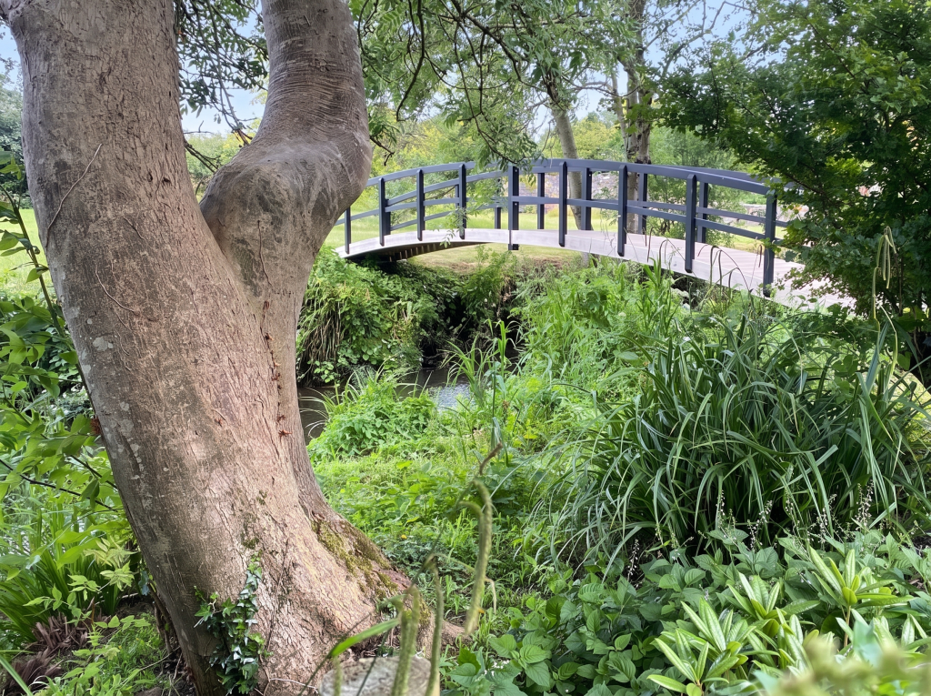 Footbridge over the River Thaw among trees, Cowbridge