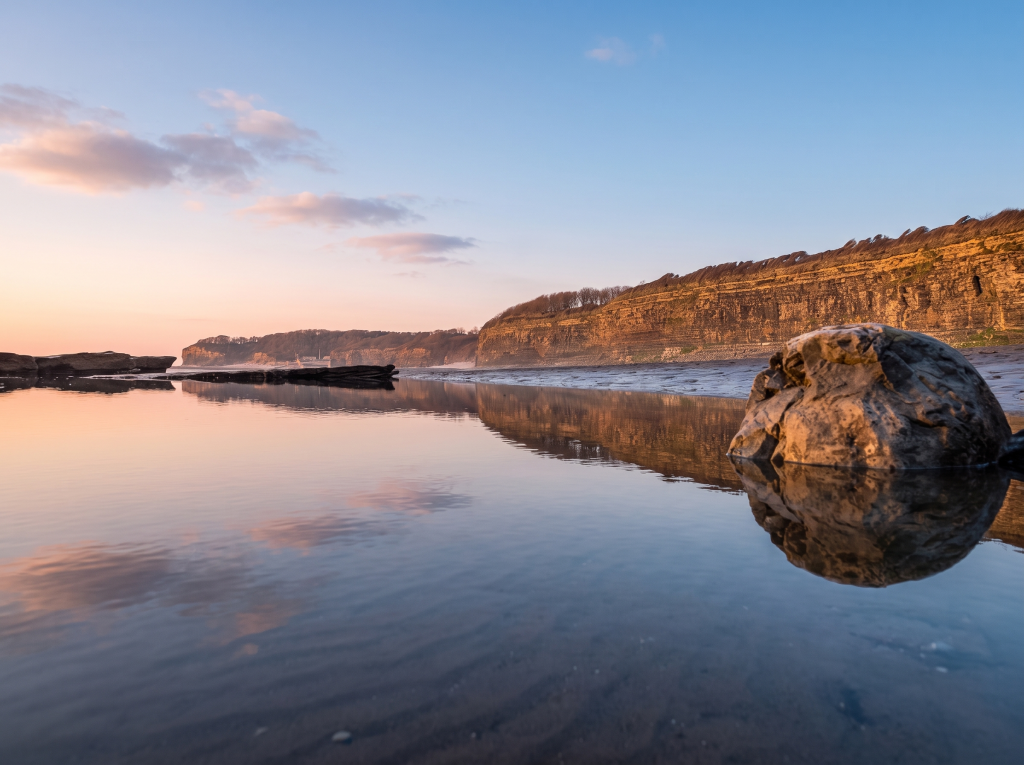 Glamorgan Heritage Coast at sunset, rocks reflected in still water