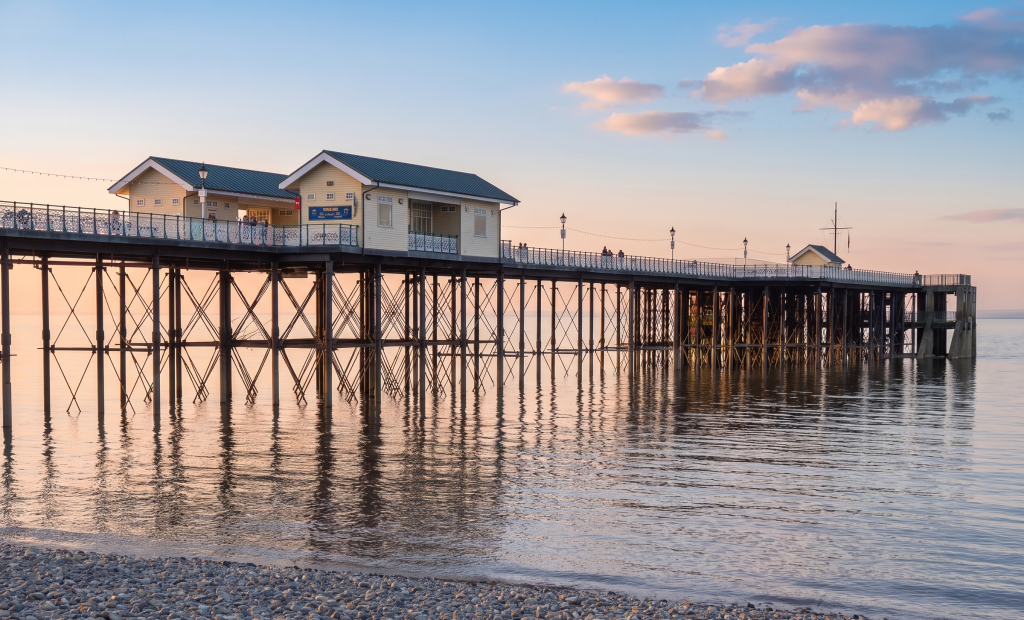 Penarth Pier at sunset, reflected in a calm sea